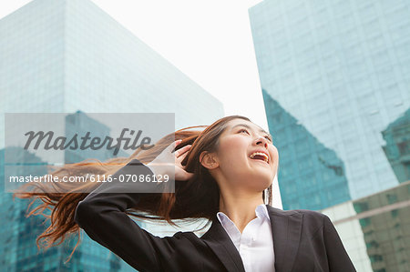 Young Businesswoman with hair blowing in the wind, outdoors, Beijing