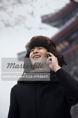 Man in Fur Hat Talking on Cell Phone
