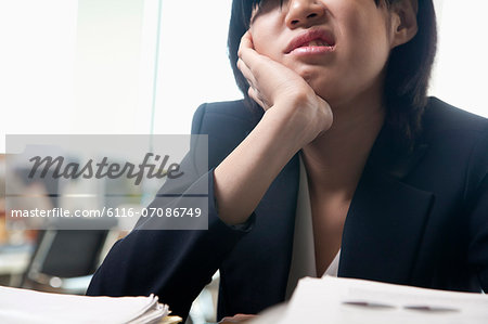 Young businesswoman sitting at desk bored