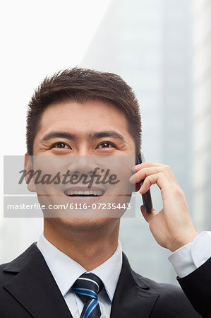 Young Businessman Smiling and Talking on Smart Phone