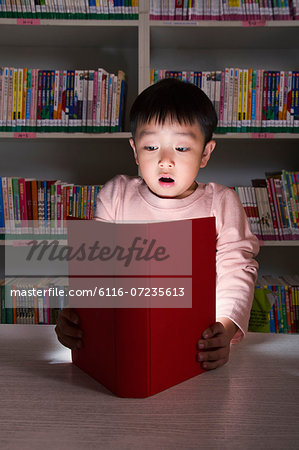 Boy Surprised By Glowing Book