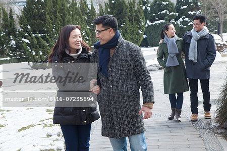 Couples in park covered in snow