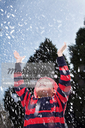 Boy with arms raised feeling the snow