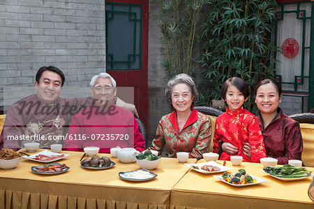 Portrait of family enjoying Chinese meal in traditional Chinese clothing