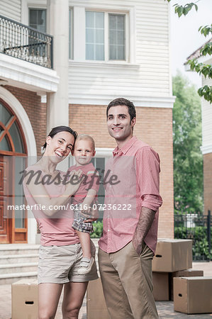 Portrait of smiling family in front of their new home