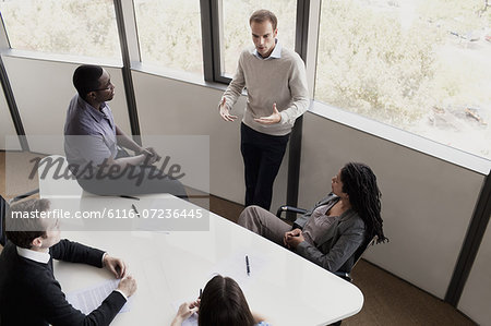 Five business people sitting at a conference table and discussing during a business meeting