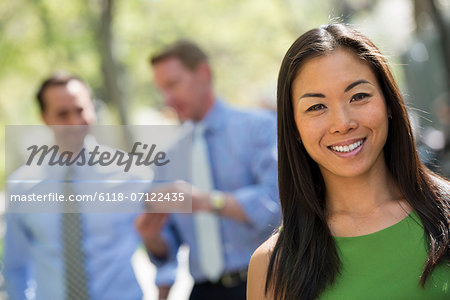 A Small Group Of People, A Businesswoman And Two Businessmen Outdoors In The City.