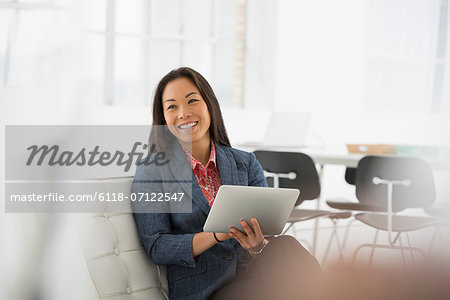 Business. A Woman Sitting Down Using A Digital Tablet.