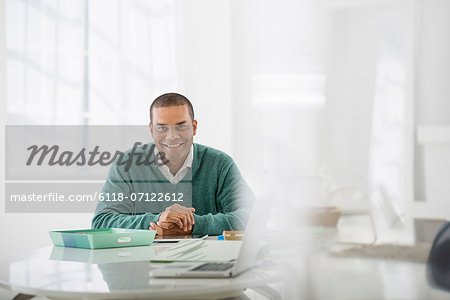 Business A Man Sitting With His Hands Clasped Behind A Desk