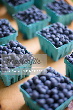 Organic fruit displayed on a farm stand. Blueberries in punnets. Organic fruit displayed on a farm stand. Blueberries in punnets.