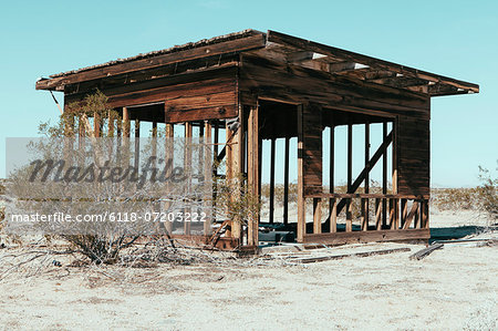 A small abandoned building in the Mojave desert landscape.