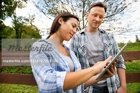 An organic farm in the Catskills. Two people looking at the screen of a digital tablet.