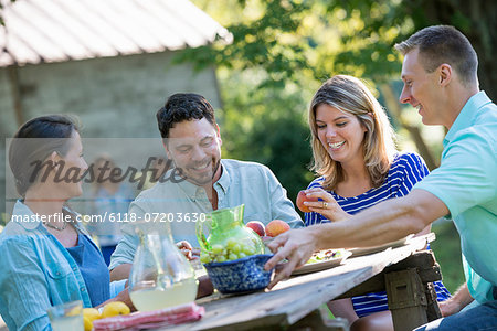 A family, adults and children seated around a table, enjoying a meal together.