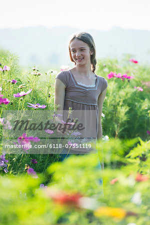 Summer on an organic farm. A young girl in a field of flowers.