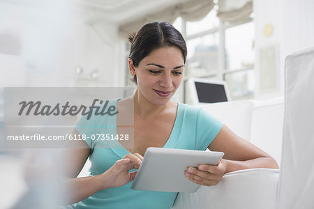 Business people. The office in summer. A young woman sitting comfortably in a quiet airy office environment. Using a digital tablet.