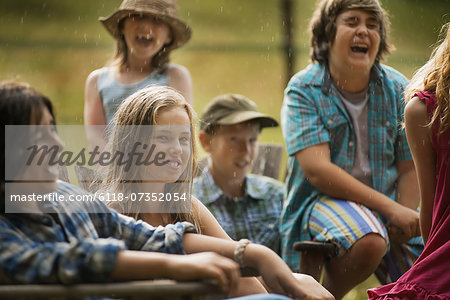 A group of young people, teenagers and children, laughing.