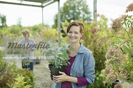Two women working in a plant house or greenhouse at an organic farm.