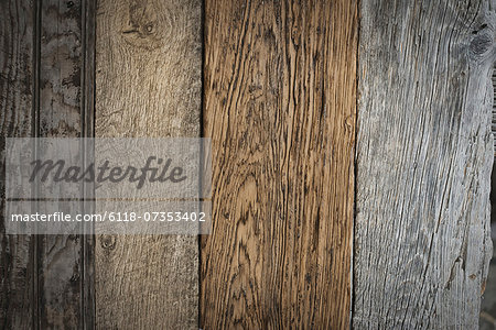 A heap of recycled reclaimed timber planks of wood. Environmentally responsible reclamation in a timber yard. Varieties of wood, with grain and colour details.