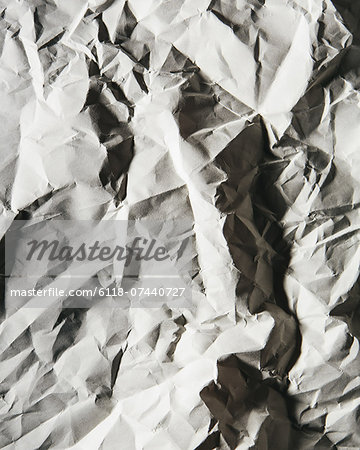 A piece of recycled white paper, crumpled and scrunched up, refuse.