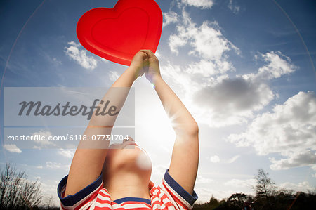 A child holding a red heart shape.