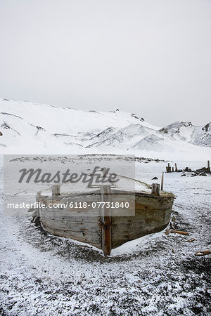 A wooden boat hull beached on Deception island, a former whaling station.