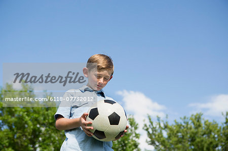 A young boy holding a soccer ball.
