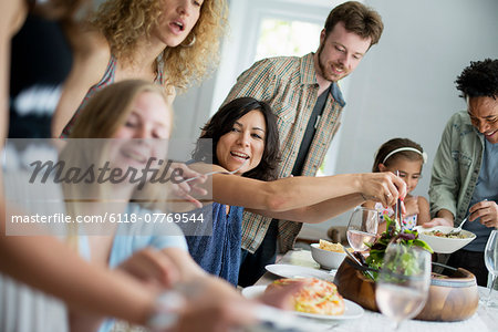 A family gathering for a meal. Adults and children around a table.