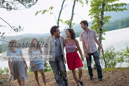 A group of people enjoying a leisurely walk by a lake.