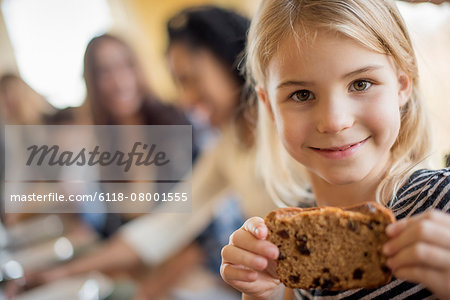 A young girl with a large cookie.