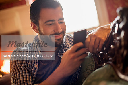 A man checking his cell phone and smiling.