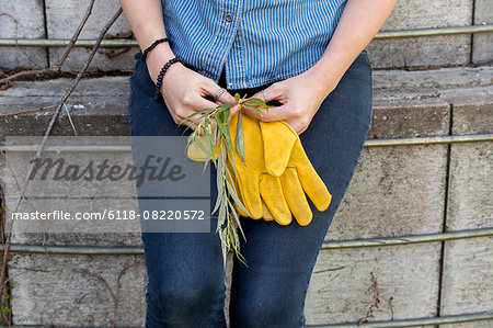 Young woman on a working farm, taking a break in the shade of a silo.