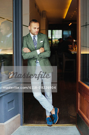 Portrait of the chef sommelier standing at the door of a city restaurant.