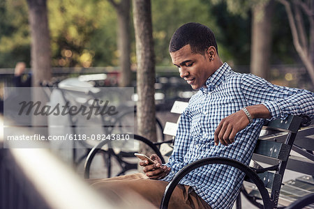 A man in a park looking at a smart phone