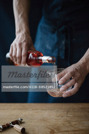 A woman pouring a drink from a bottle.