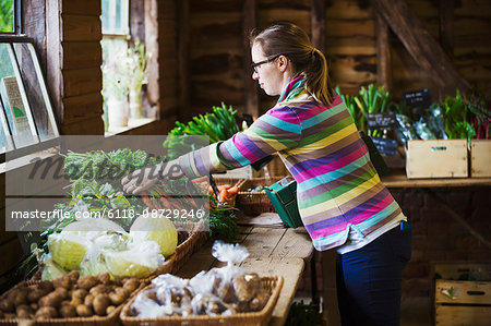 A woman handling produce in a farm shop. A woman handling produce in a farm shop.
