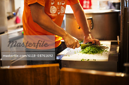 The ramen noodle shop. A chef chopping vegetables.