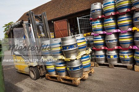 Stacks of metal beer cags on a forklift truck in a brewery.
