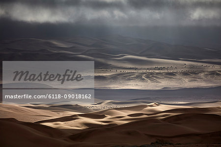 Sand dunes under a stormy sky.