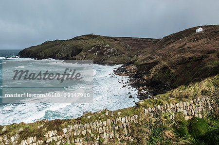 Cot Valley, St Just. View down from the cliff path over the bay and waves crashing against the cliffs. A stormy day.