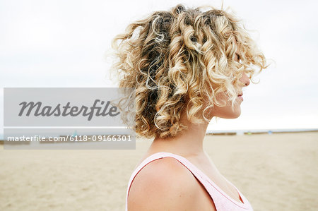 Profile Portrait Of Young Woman With Blond Curly Hair Standing On