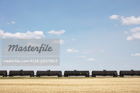 Oil train cars and fallow farmland, near Swift Current, Saskatchewan, Canada. Oil train cars and fallow farmland, near Swift Current, Saskatchewan, Canada.