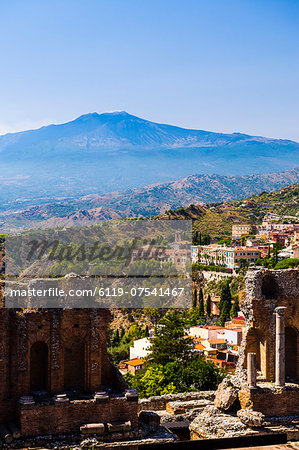 Mount Etna Volcano with ruins of Teatro Greco (Ancient Theatre) of Taormina in the foreground, Sicily, Italy, Europe