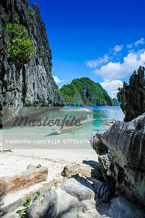 Outrigger boat on a little white beach and crystal clear water in the Bacuit archipelago, Palawan, Philippines, Southeast Asia, Asia