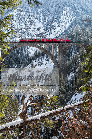 The Bernina Express crossing the Wiesen Viaduct in the Swiss Canton of Graubunden, Switzerland, Europe