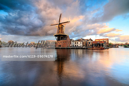 Pink clouds at sunset on the Windmill De Adriaan reflected in the River Spaarne, Haarlem, North Holland, The Netherlands, Europe