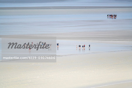 People walking on the sand during low tide, Mont-Saint-Michel, Normandy, France, Europe