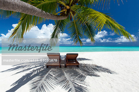 Two deck chairs under palm trees and tropical beach, The Maldives, Indian Ocean, Asia