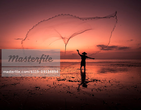 Sunrise fisherman casting his net, Bali, Indonesia, Southeast Asia, Asia