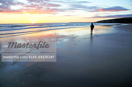A woman walks on Southerndown beach, Ogmore, South Wales, United Kingdom, Europe