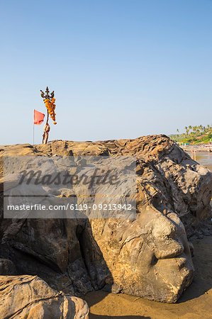 Stone face of Lord Shiva carved into rock, Ozran Beach known as Little Vagator Beach, Goa, India, Asia